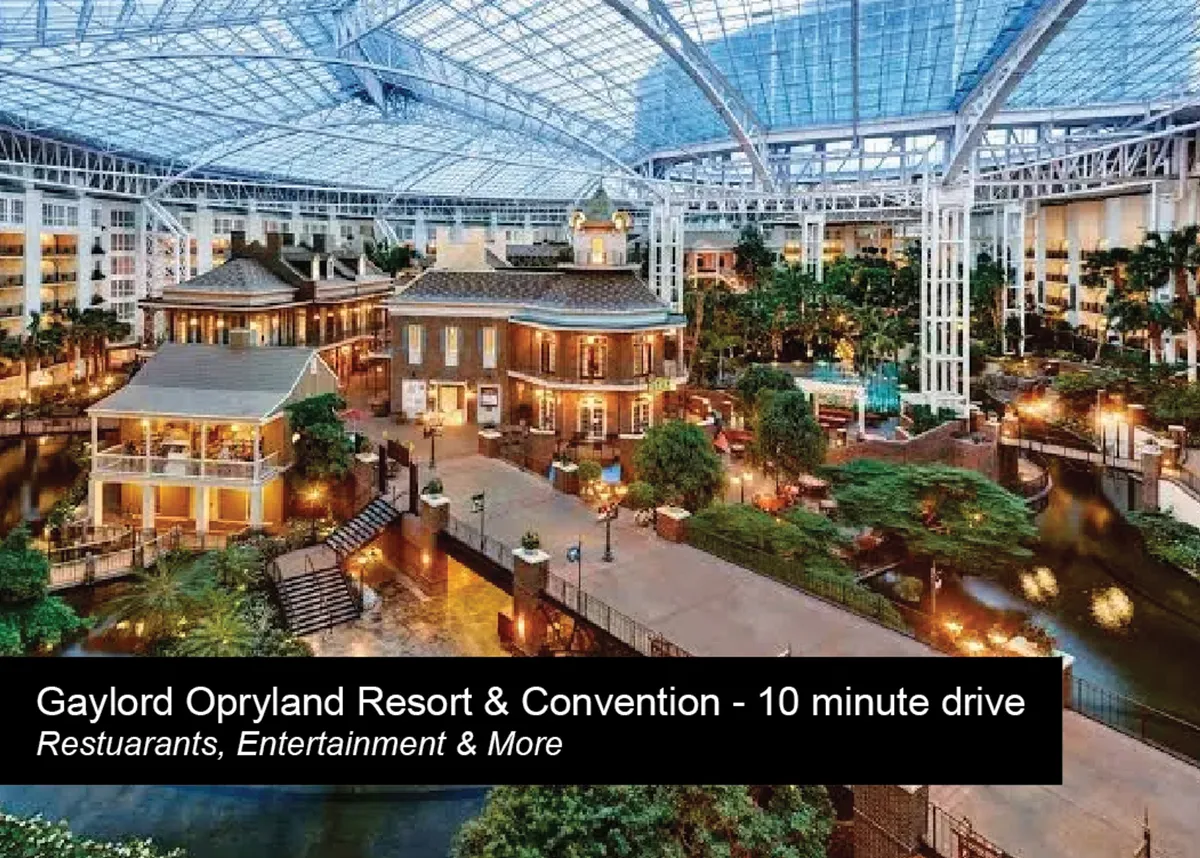 An inviting shot of a central atrium with water features, tropical plants, and buildings resembling a Southern mansion. The lively space is filled with people relaxing, exploring, and enjoying the festive ambiance—evoking the atmosphere of a premier shopping or entertainment destination like Opry Mills.